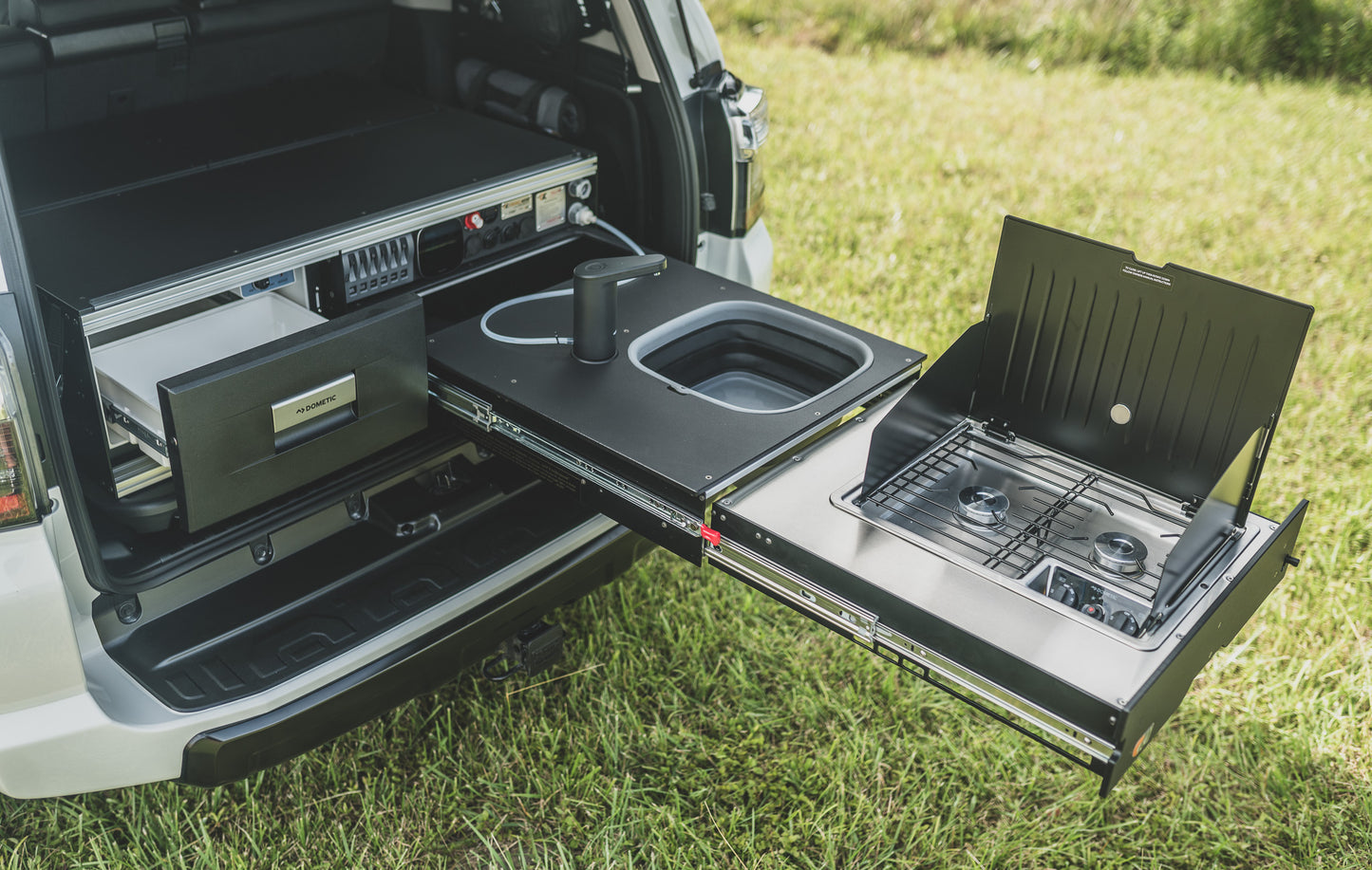 Overland Kitchen with refrigerator drawer, counter top, faucet & sink, and two burner cooktop.